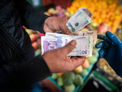 Un comprador paga por productos agrícolas en un mercado de alimentos en Bogotá, Colombia, en una imagen de marzo de 2023.
