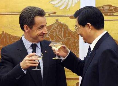 El presidente francés, Nicolás Sarkozy, brinda con su homólogo chino, Hu JIntao, ayer en Pekín.