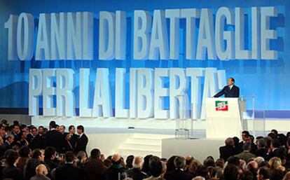 Ante un panel que dice "10 años de lucha por la libertad", Berlusconi se dirige, ayer, a los asistentes a la celebración del 10º aniversario de Forza Italia.
