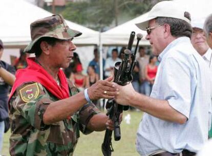 El alto comisionado para la Paz, Luis Carlos Restrepo (derecha), recibe el arma de un paramilitar desmovilizado, el pasado febrero.