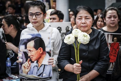 Tailandeses muestran su respeto mientras esperan el inicio del cortejo fúnebre del rey Bhumibol Adulyadej desde el hospital Siriraj en Bangkok (Tailandia).