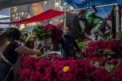 Comerciantes de flores descargan un camión en el tradicional mercado de Jamaica.