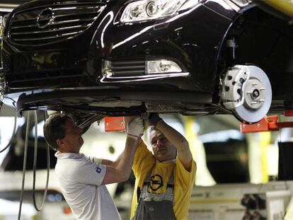 Dos operarios trabajan en una cadena de montaje de la automovilística Opel, en Ruesselsheim.