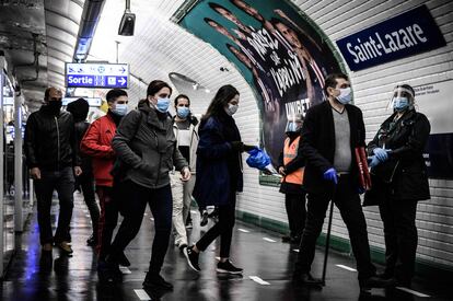 Varios usuarios con mascarilla en el interior de la estación Saint-Lazare del metro de París.