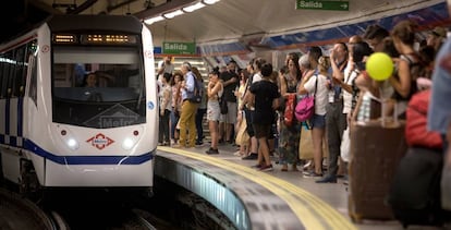 Un tren llega al andén repleto de viajeros de la estación de metro de Sol.
