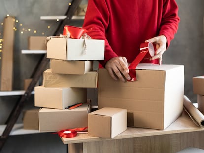 Un comerciante empaqueta regalos de Navidad en una tienda.