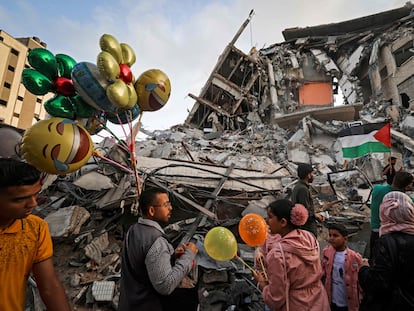 Un hombre palestino vende globos frente a un edificio destruido por los ataques aéreos israelíes, este viernes en Gaza.