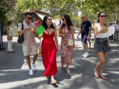 Un grupo de turistas se refresca con abanicos en una calle céntrica en Sevilla el pasado sábado.