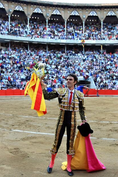 José Tomás recoge unas flores y una <i>senyera</i> antes del inicio de la corrida.