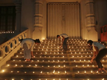 Varias personas encienden velas en la puerta de una iglesia de Colombo en recuerdo de los recientes atentados terroristas en Sri Lanka.