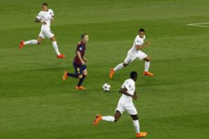 Iniesta rodejat de jugadors del PSG.