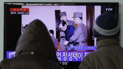 Dos surcoreanos ven por televisi&oacute;n la noticia, en Se&uacute;l.