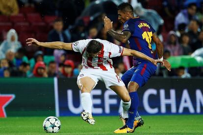 El jugador del Barcelona Paulinho (d) pelea un balón contra el jugador del Olympiakos Omar Elabdellaoui (i).