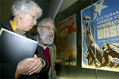 El cartelista Carles Fontserè y su esposa, Terry, contemplan algunos carteles expuestos en <b></b><i>Propaganda en guerra,</i> ayer en Salamanca.