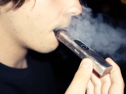 Un joven usa un cigarrillo electrónico o váper, en una terraza de un bar de Madrid.