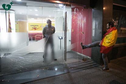 Un manifestante da una patada a la puerta de la emisora de Catalunya Radio.