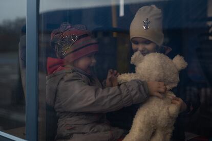 Dos niñas ucranias esperan la salida del autobús que las llevará de Zaporiyia a un refugio temporal.