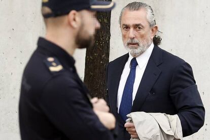 Francisco Correa junto a uno de los policías que custodian el edificio donde se juzga el 'caso Gürtel'.
