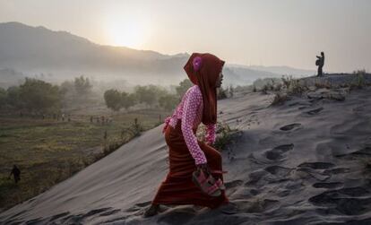 Una joven camina por las dunas de la playa Parangkusumo en Yogyakarta, Indonesia.