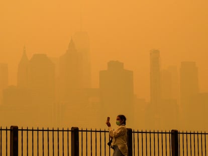 Una mujer con mascarilla fotografía el cielo de Nueva York el 7 de junio.