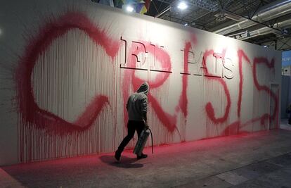 Stand de EL PAÍS en la edición de ARCO del año 2012 con la palabra Crisis. Tuvieron cabida varias intervenciones de artistas urbanos. En la imagen, Neko poniendo la palabra crisis en una de las paredes de la instalación.