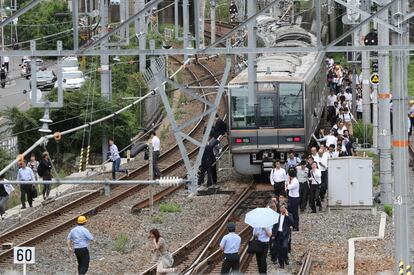 El seísmo, por el que no se activó la alerta de tsunami, alcanzó el nivel 6 bajo en la escala japonesa cerrada de 7 grados (centrada en el grado de agitación en la superficie) en la prefectura de Osaka y de 5 alto en la vecina prefectura de Kioto. En la imagen, vista de un muro caído de un colegio en TAkatsuki, el 18 de junio de 2018. En la imagen, varios pasajeros de un tren caminan a lo largo de las vías del ferrocarril después del terremoto en Osaka, el 18 de junio de 2018.