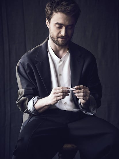 Radcliffe se lía un cigarro vestido con chaqueta ‘oversize’, pantalón con costura vertical y camisa sin cuello; todo, Louis Vuitton.