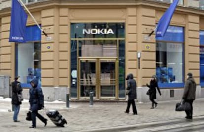 Varios viandantes pasan delante de una tienda que la fabricante de teléfonos móviles Nokia tiene en Helsinki (Finlandia).