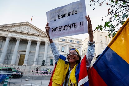 Una mujer venezolana muestra un cartel de apoyo al opositor Edmundo González, este martes frente al Congreso de los Diputados en Madrid.