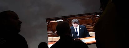 Partidarios de la independencia de Catalu&ntilde;a siguen el discurso de Puigdemont del 10 de octubre en una pantalla gigante en Barcelona.