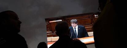 Partidarios de la independencia de Cataluña siguen el discurso de Puigdemont del 10 de octubre en una pantalla gigante en Barcelona.