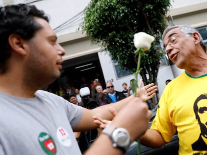 Um eleitor de Fernando Haddad oferece uma flor a um eleitor de Jair Bolsonaro, durante a jornada de segundo turno em um colégio eleitoral de São Paulo.