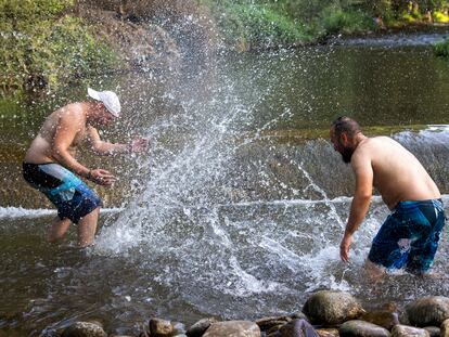 Dos hombres se refrescan en el río Iregua en Logroño, este sábado.