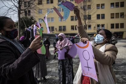 Unas mujeres tienden ropa simbólica, prendas hechas de cartulina con palabras como "valiente" o "paciente", en una concentración feminista en Madrid celebrada este lunes con motivo del 8-M.