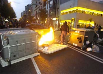 Encapuchados queman contenedores en Barcelona en protesta por un desalojo de okupas.