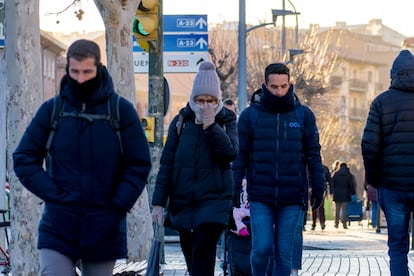 Personas fuertemente abrigadas caminan por una calle de la ciudad de Teruel este lunes.