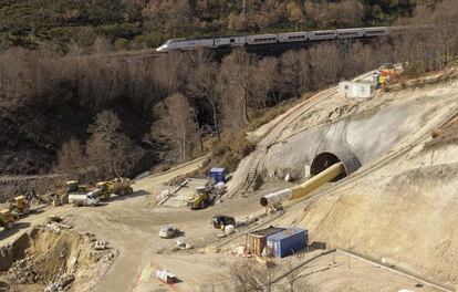 Un tren circula junto a las obras del nuevo t&uacute;nel de O Padornelo tras salir del actual, que se seguir&aacute; usando para la alta velocidad.