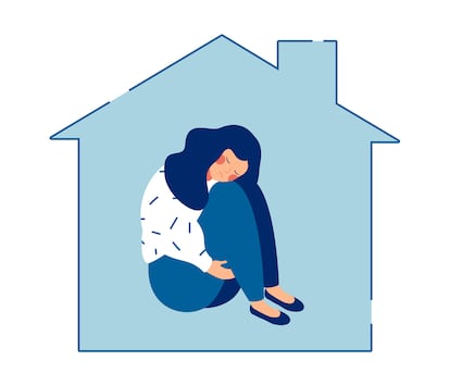 Young sad woman sits alone at home and hugging her knees