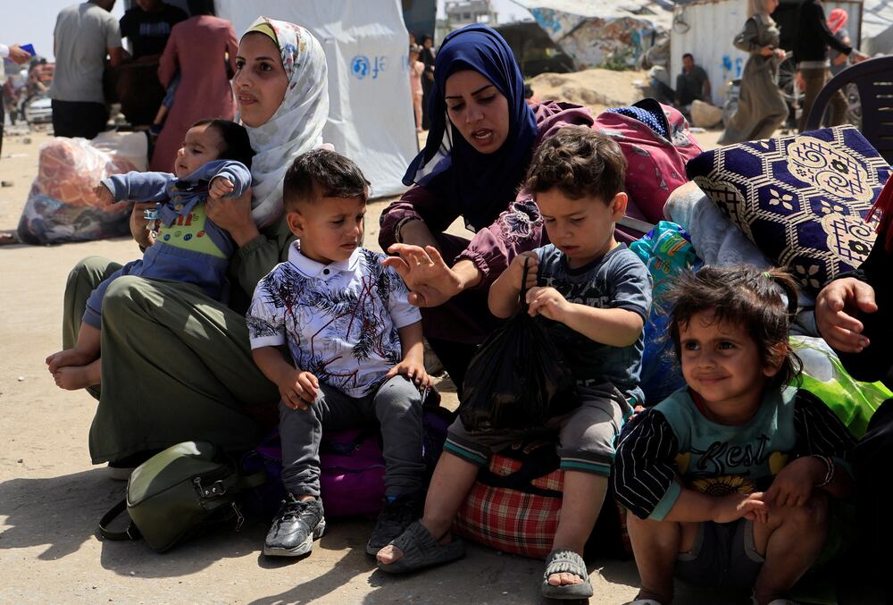Palestinian women and children rest with their belongings as they flee their homes after the Israeli military issued orders for evacuation from eastern Khan Younis, in the southern Gaza Strip, May 19, 2025. REUTERS/Hatem Khaled