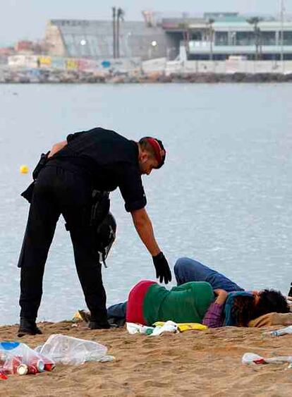 Una pareja descansa en la playa de Barceloneta de Barcelona.