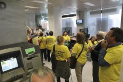 GRA142 CIUDAD REAL, 22/04/2013.- Grupo de integrantes de la Plataforma de Afectados por las Preferentes de Puertollano, que esta mañana han ocupado una oficina de Bankia situada en el centro de Ciudad Real, donde medio centenar de personas han conseguido entrar en el interior de la sucursal bancaria después de varios intentos que han sido impedidos por la seguridad privada y por agentes de la Policía Nacional. EFE/Mariano Cieza Moreno