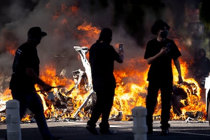Manifestantes frente a un coche en llamas, en Los Ángeles.