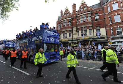 Varios policías protegen el autobús del Chelsea durante el recorrido.