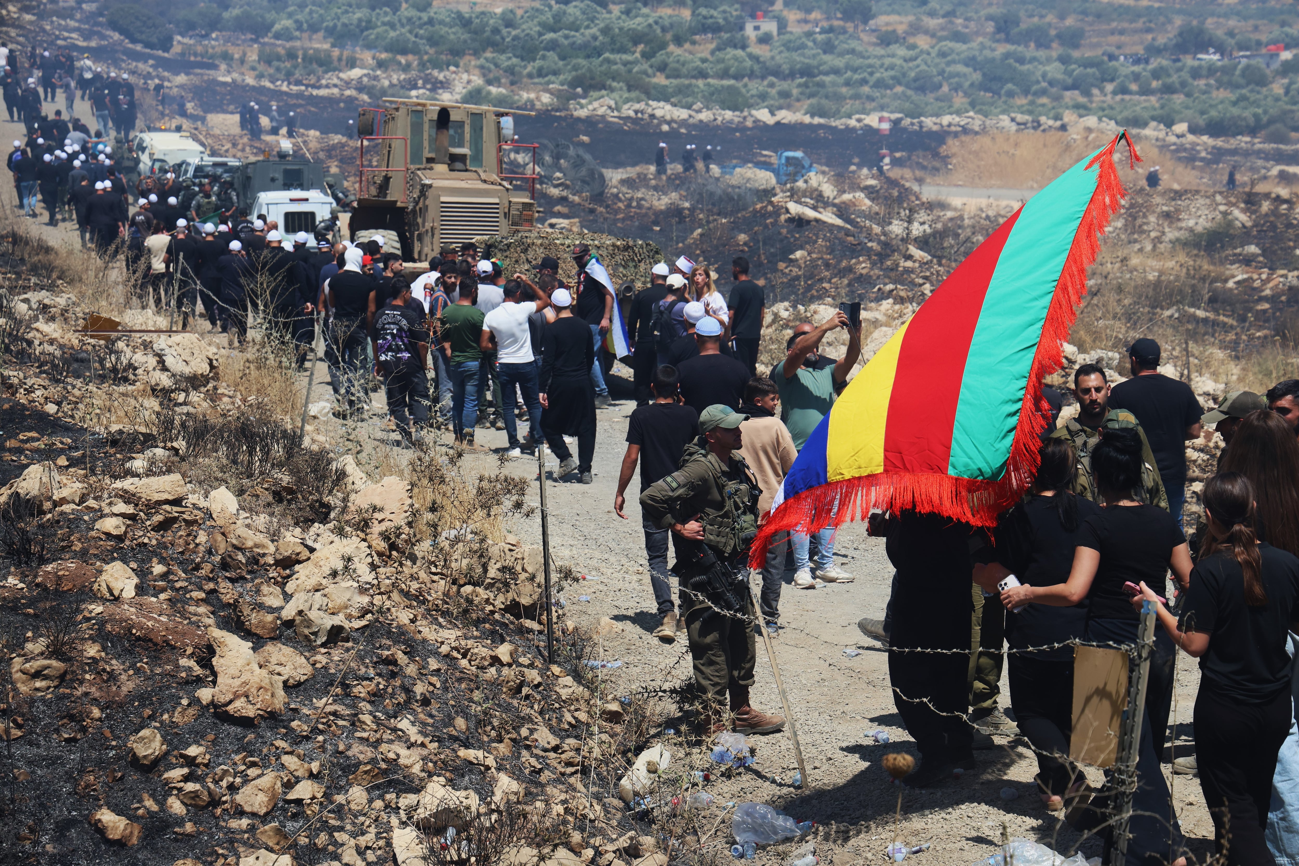Un militar israelí observa a cientos de personas yendo de uno a otro lado de la valla que separa zona en los Altos del Golán la zona ocupada por Israel de la administrada por Damasco.