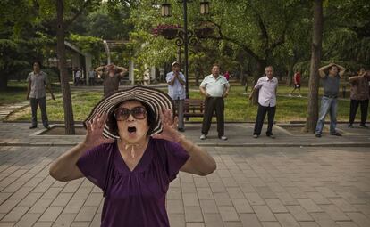 Una mujer china grita durtante su ejercicio matinal en el parque Ritanen Pekín, China.