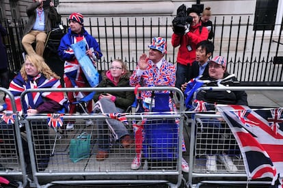 Seguidores de la monarquía británica esperan a las afueras del palacio de St. James, la llegada de la reina y los duques de Cambridge con su hijo de tres meses.