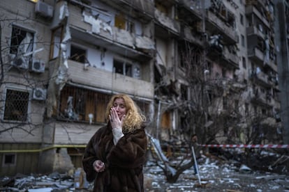 Una mujer llora junto a su casa tras un bombardeo en Kiev.