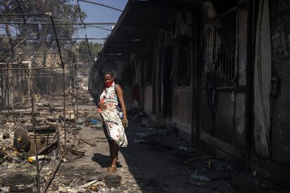 En la foto, una mujer embarazada observa los destrozos del fuego.