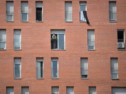 Un vecino fuma en una ventana de la calle Urrutia, en Nou Barris