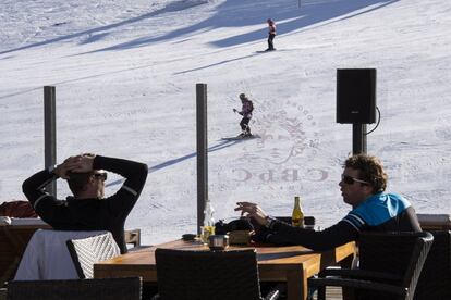 Dos clientes descansan frente a las piastas de esquí de Pas de la Casa del grupo Grandvalira.